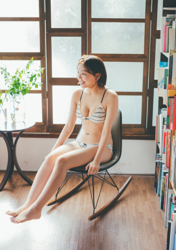 Ms. Ami Ojimi is a young gravure idol (bikini model / swimwear model) and a young and cute actress, she is wearing a white bikini and sitting on a chair.