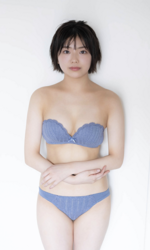 Ms. Ami Ojimi is a young gravure idol (bikini model / swimwear model) and a young and cute actress, she is wearing a blue bikini and she is standing.