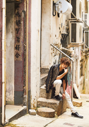 Mr. Ayato Akaibashi is sitting on a street corner in hong kong, he is also an actor and voice actor.