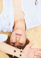 Mr. Ayato Akaibashi is wearing a white shirt and lying on the sandy beach, he is also an actor and voice actor.