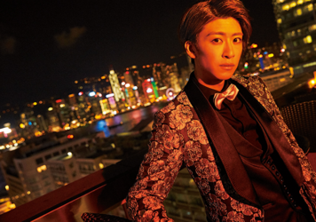 Mr. Ayato Akaibashi is wearing a suit and sitting on a chair, he is also an actor and voice actor.