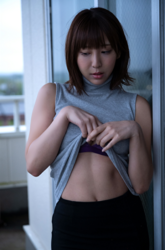 Ms. Kirina Hinaga is wearing a gray shirt and black skirt, with her shirt off to show her belly, she is a Japanese & Asian sweet and cute big breasts gravure idol (pin-up model, bikini model, swimsuit model), her bust is 90 cm, she has charming big breasts, she is a woman with sexual charm.