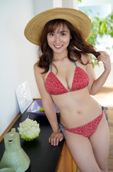 Ms. Yaaya Igeta is wearing a red bikini, standing in a room and wearing a straw hat, she is a Japanese & Asian gravure idol (bikini model, swimsuit model, pin-up girl), actress, TV personality, her bust is 92 cm, she has attractive big breasts, she is a sexually attractive woman.
