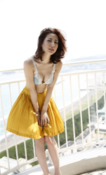 Ms. Yumika Sugiomi is wearing light blue underwear and a yellow skirt and she is standing on the roof, she is a beautiful and elegant Japanese & Asian fashion model, gravure idol (bikini model, swimsuit model, pin-up girl), actress, female singer, her bust is 84 cm, she has beautiful breasts, she has attractive women.