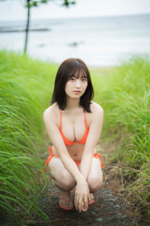 Ms. Asumi Saigosawa is wearing an orange bikini swimsuit and squatting in a field, she is a very cute and young actress who is also active as a bikini model (swimsuit model / gravure idol / pin up girl).