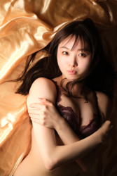 Ms. Makiko Tatsuhashi is wearing black lingerie and lying on a brown bed, she is an active idol singer and gravure idol (bikini model, swimwear model).