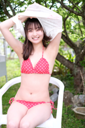 Ms. Makiko Tatsuhashi is in the process of taking off her white shirt and reveals a red polka dot bikini, she is sitting in a white chair now, she is an active idol singer and gravure idol (bikini model, swimwear model).