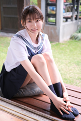 Ms. Makiko Tatsuhashi is wearing a sailor suit (girl's school uniform) and she is sitting, she is an active idol singer and gravure idol (bikini model, swimwear model).
