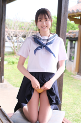 Ms. Makiko Tatsuhashi is wearing a sailor suit (girl's school uniform), she is standing with her knees bent, she lifts up her skirt and shows her yellow panties, she is an active idol singer and gravure idol (bikini model, swimwear model).