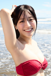 Ms. Uuna Tadekawa is a beautiful and cute young Japanese gravure idol (pin-up girl, swimwear model, bikini model), she is wearing a red bikini, standing on the sand, facing straight ahead.